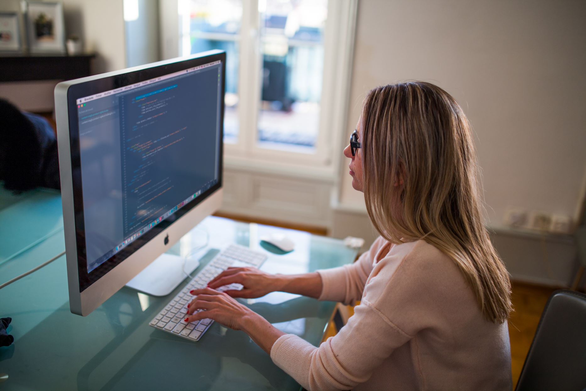 person coding on an imac in the room