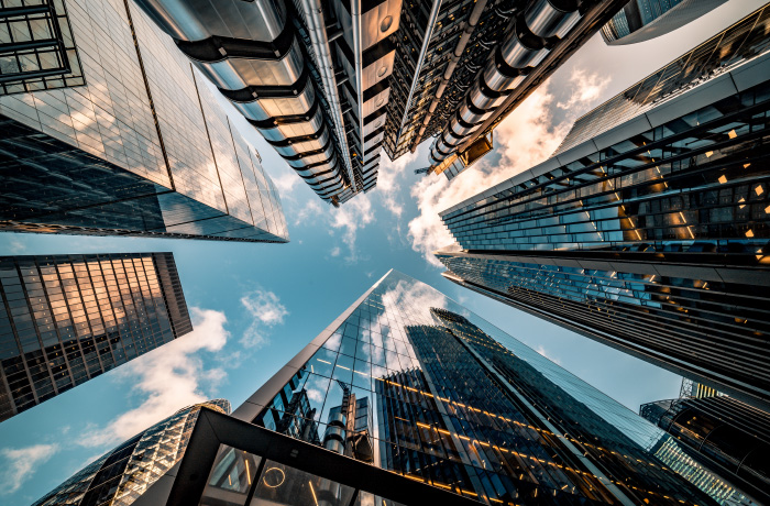 view of city buildings from ground level, looking up to the sky