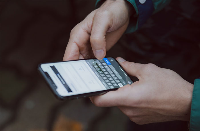 person typing on smartphone