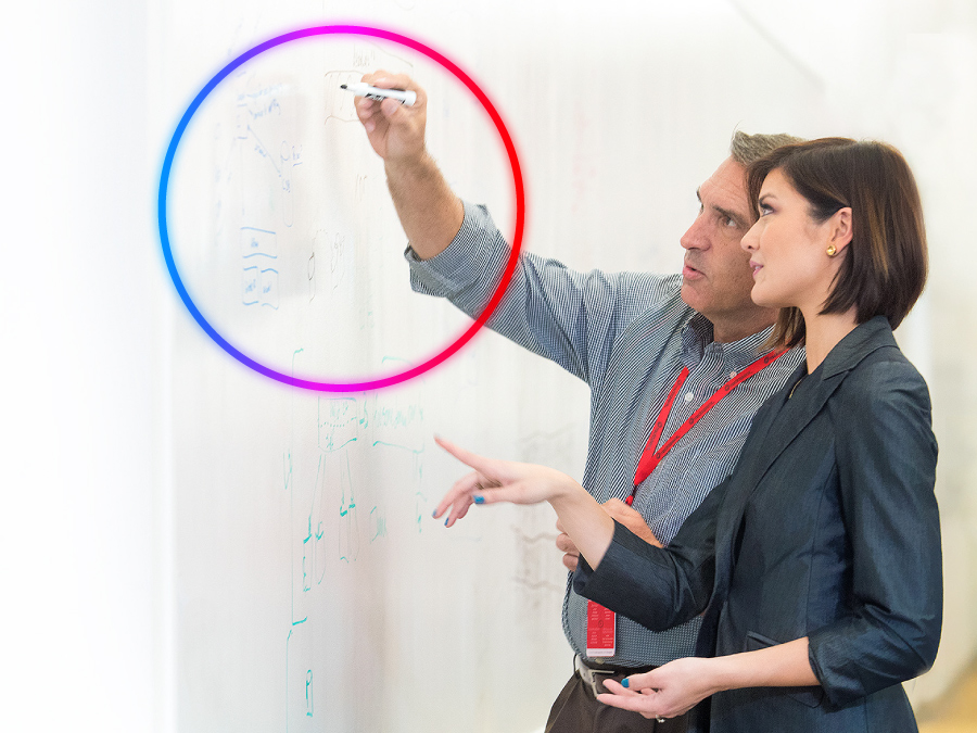 Two Rackspace Technology professionals mapping out a process on a whiteboard