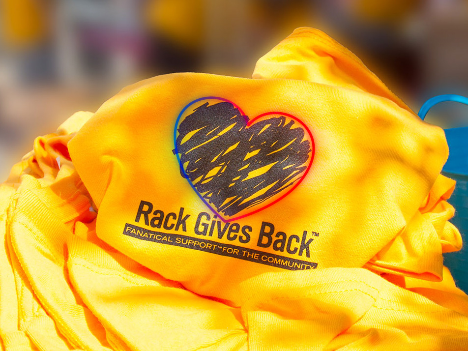A yellow shirt with Rack Gives Back