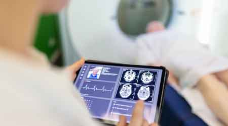 Woman scrolling in a tablet looking at the MRI results