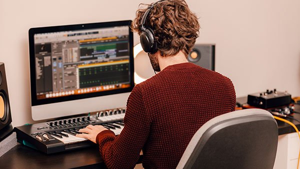 Man with headphones working in music editing