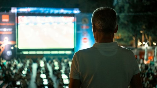 Man watching a big screen outdoors