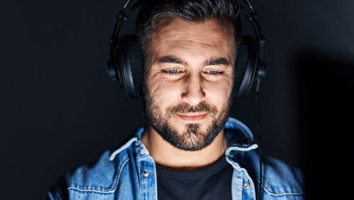 Man with the face illuminated and wearing headphones