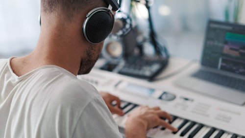 Man with headphone playing musical keyboard